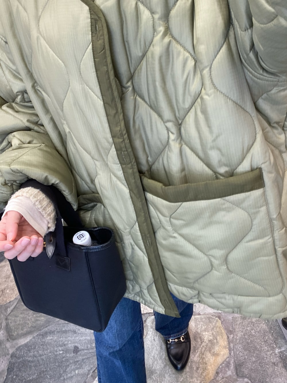 ホワイト系のニット/セーター、ブラック系のローファーを着用したレディースの冬コーディネートの2枚目の写真