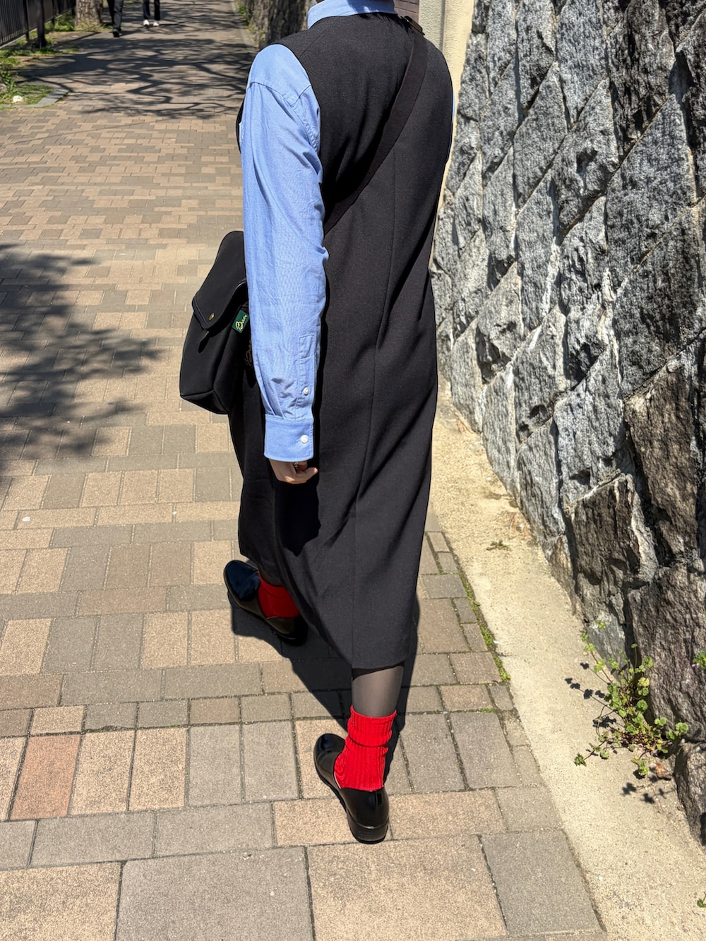 ブラック系のドレスシューズ、ブラック系のショルダーバッグを着用したレディースの春コーディネートの2枚目の写真