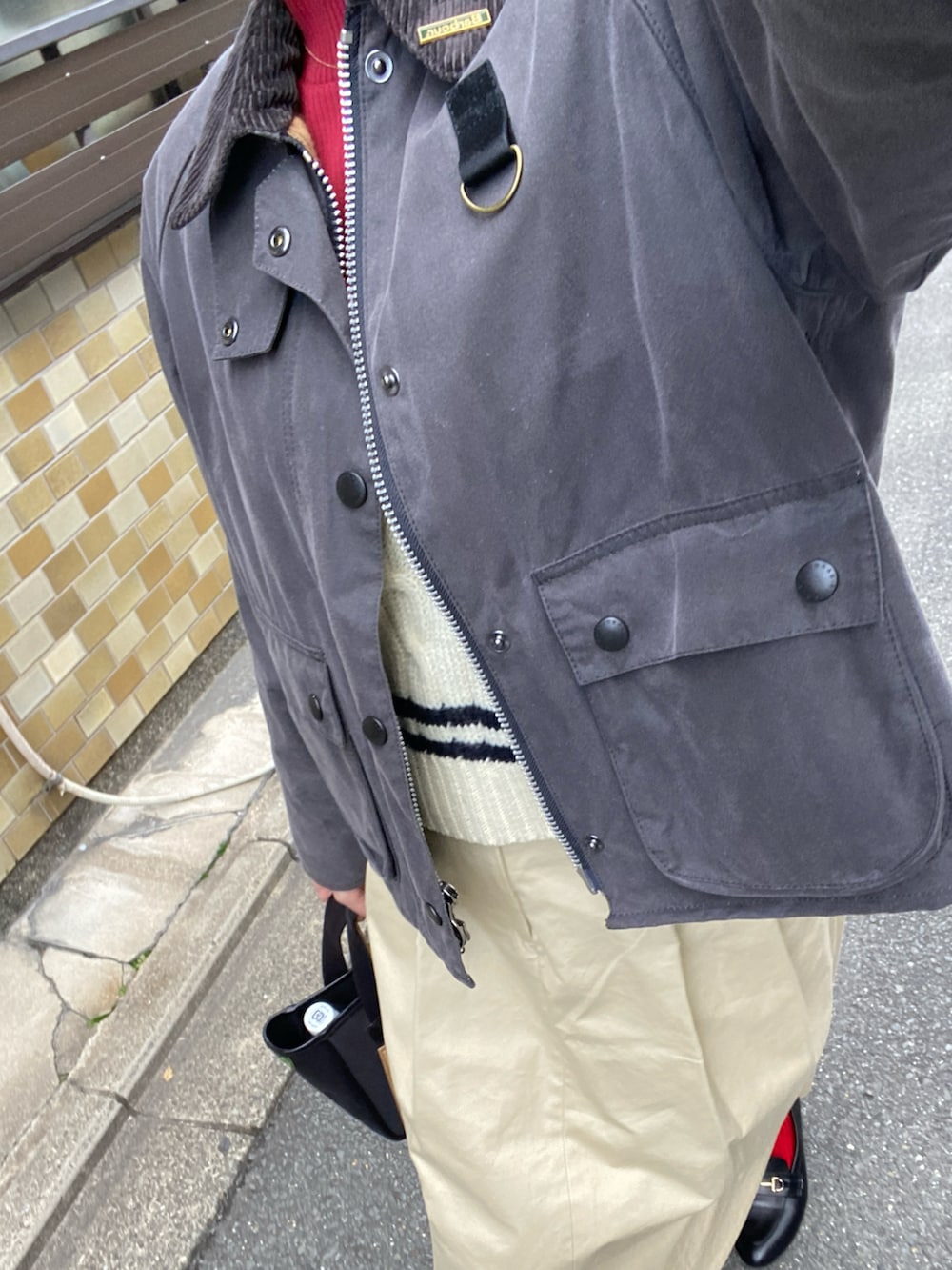 ベージュ系のスカート、ブラック系のトートバッグ、グレー系のジャケット/アウターを着用したレディースの春コーディネートの2枚目の写真