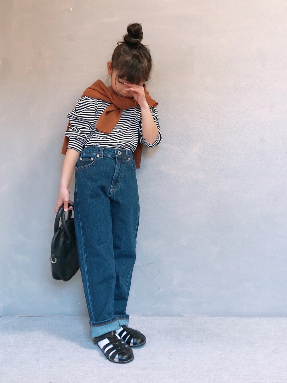 ブルー系のその他パンツ、ブラック系のサンダル、ブラック系のボストンバッグを着用したキッズの春コーディネートの2枚目の写真