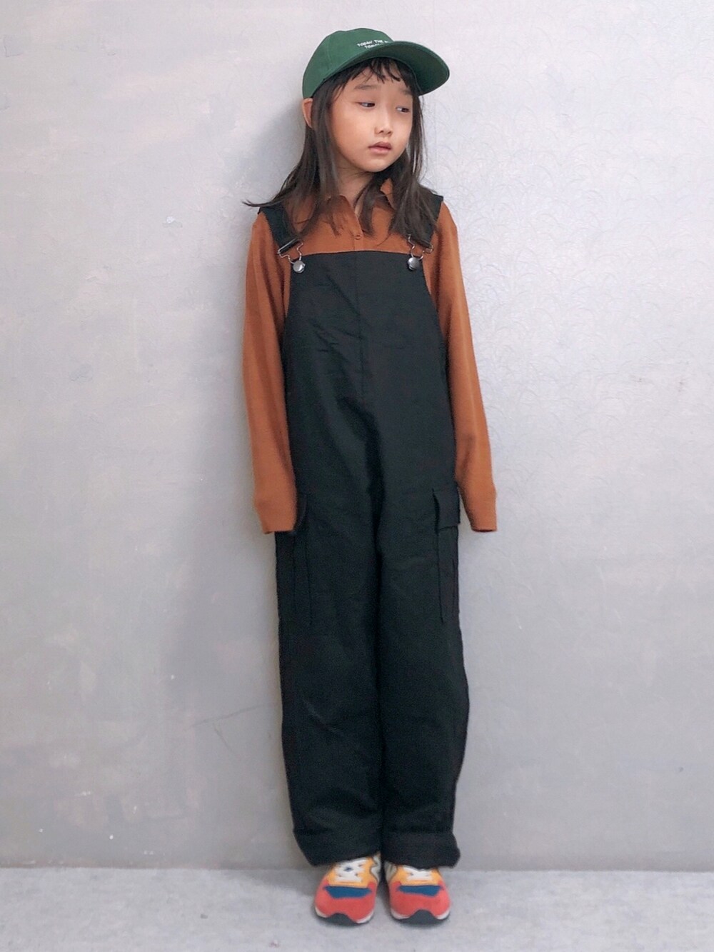 イエロー系のニット/セーター、ブラック系のサロペット/オーバーオール、その他のスニーカーを着用したキッズの秋コーディネートの2枚目の写真