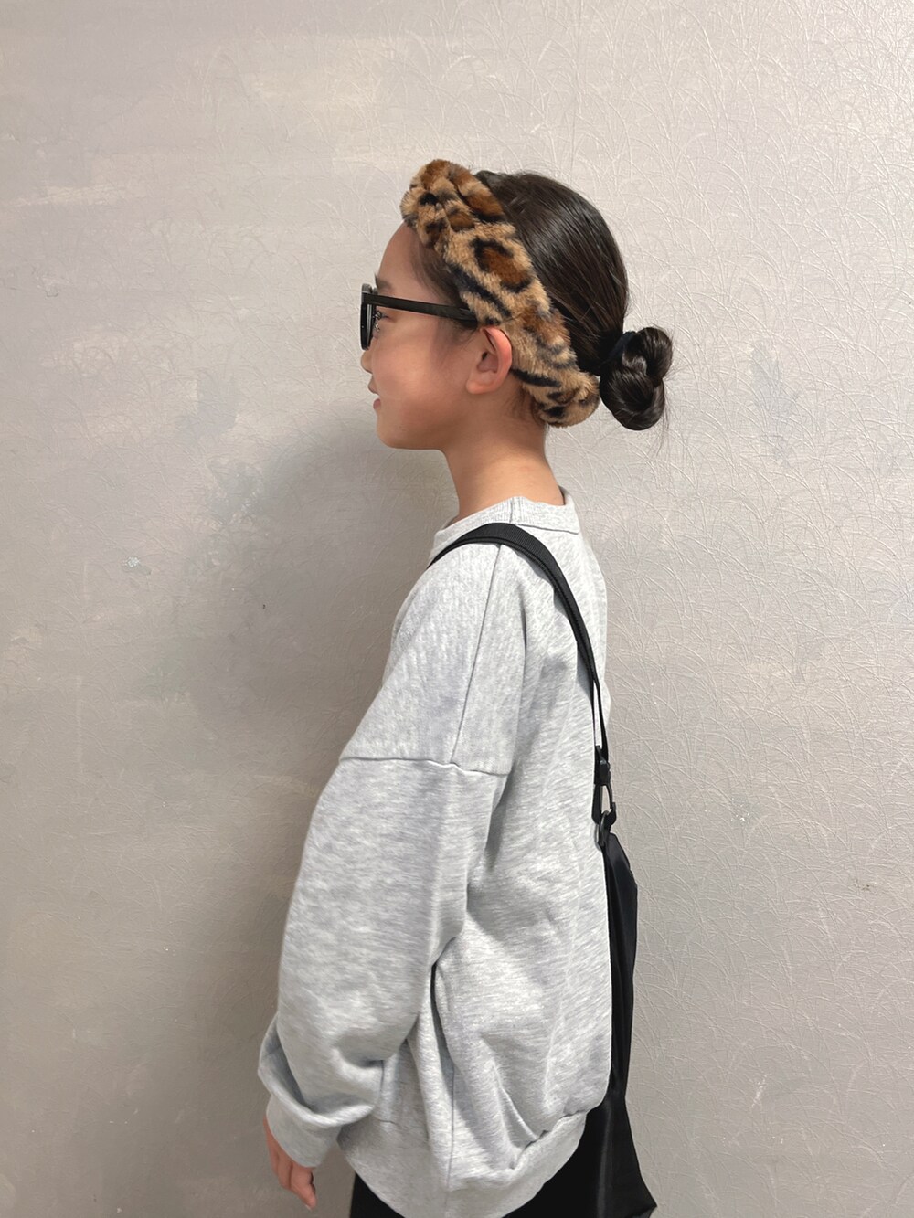 グレー系のスウェット、ブラック系のエコバッグ/サブバッグ、ブラウン系のヘアバンドを着用したキッズの秋コーディネートの3枚目の写真