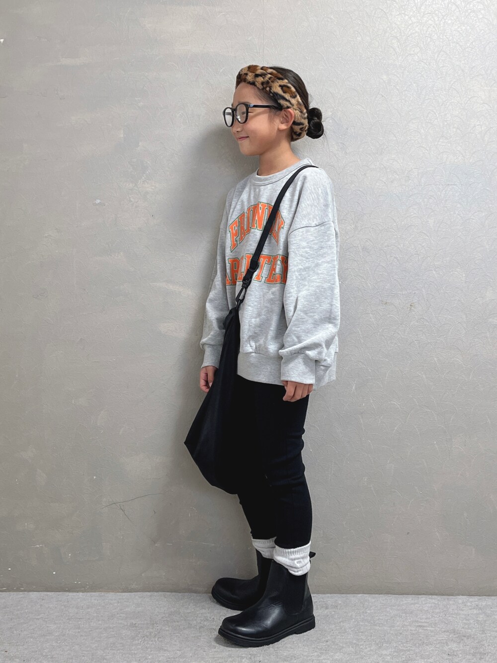 グレー系のスウェット、ブラック系のエコバッグ/サブバッグ、ブラウン系のヘアバンドを着用したキッズの秋コーディネートの2枚目の写真