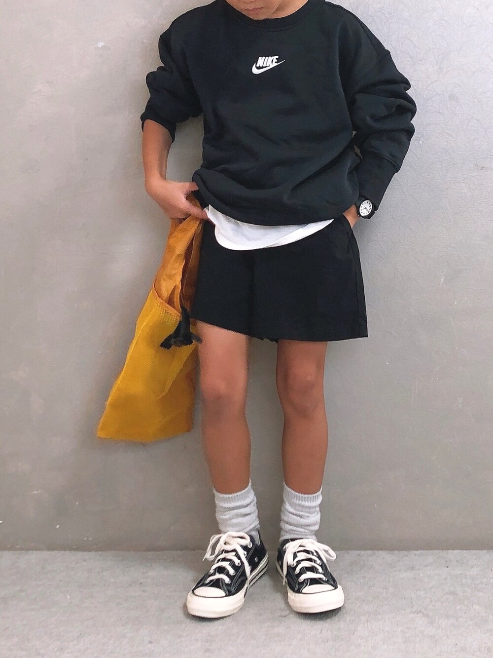 ブラック系のその他パンツ、イエロー系のエコバッグ/サブバッグ、ホワイト系のキャップを着用したキッズの秋コーディネートの3枚目の写真