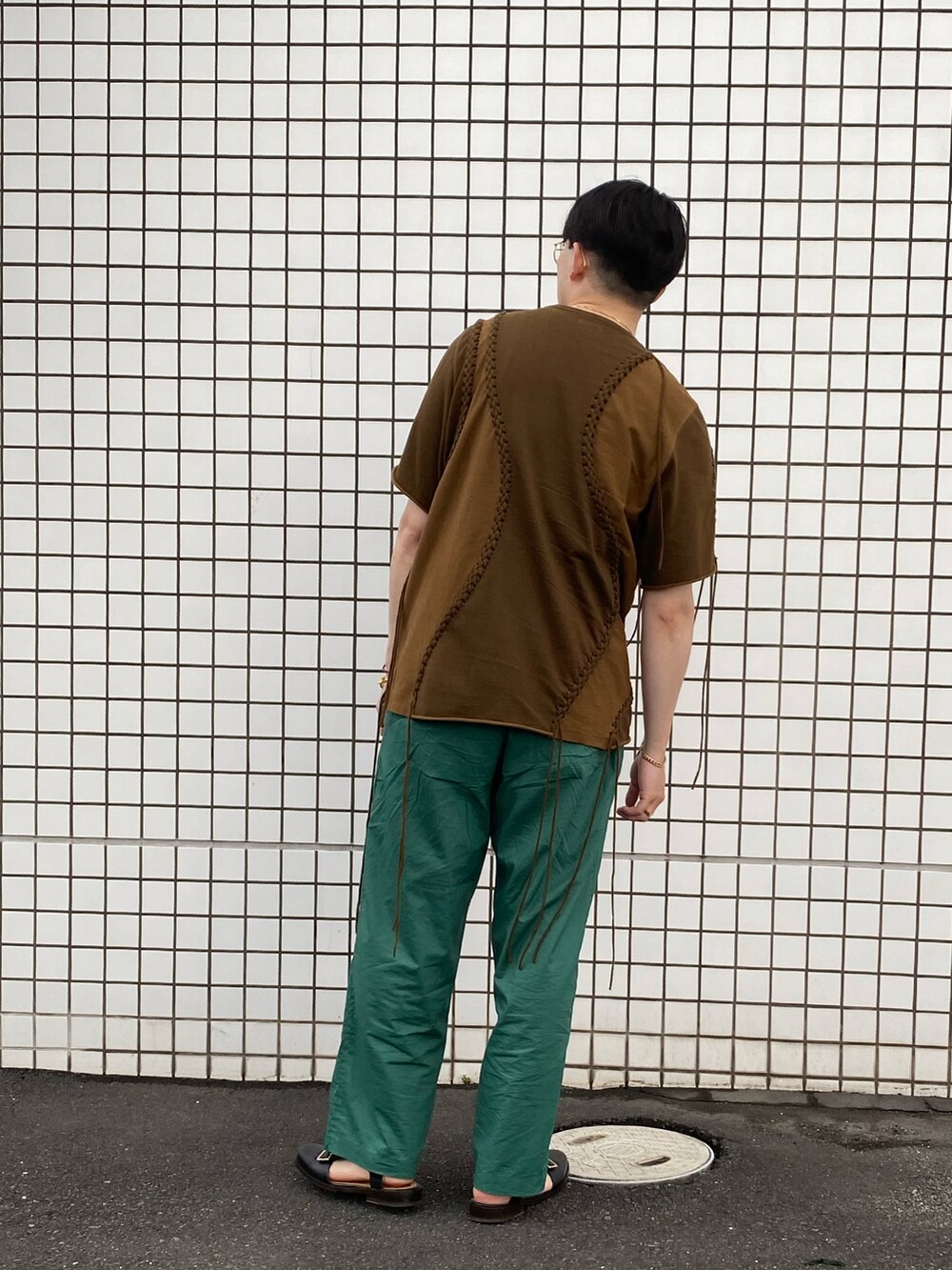 ブラウン系のTシャツ/カットソー、グリーン系のパンツ、ブラック系のシューズを着用したメンズの夏コーディネートの2枚目の写真