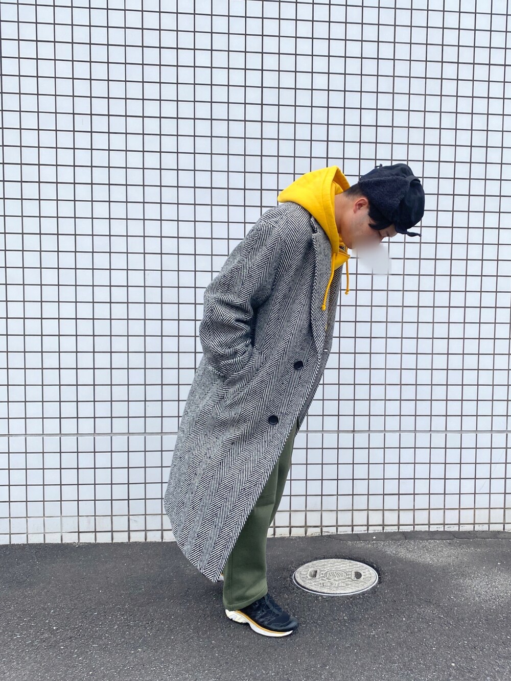 イエロー系のパーカー、グレー系のチェスターコート、グリーン系のスウェットパンツを着用したメンズの冬コーディネートの2枚目の写真