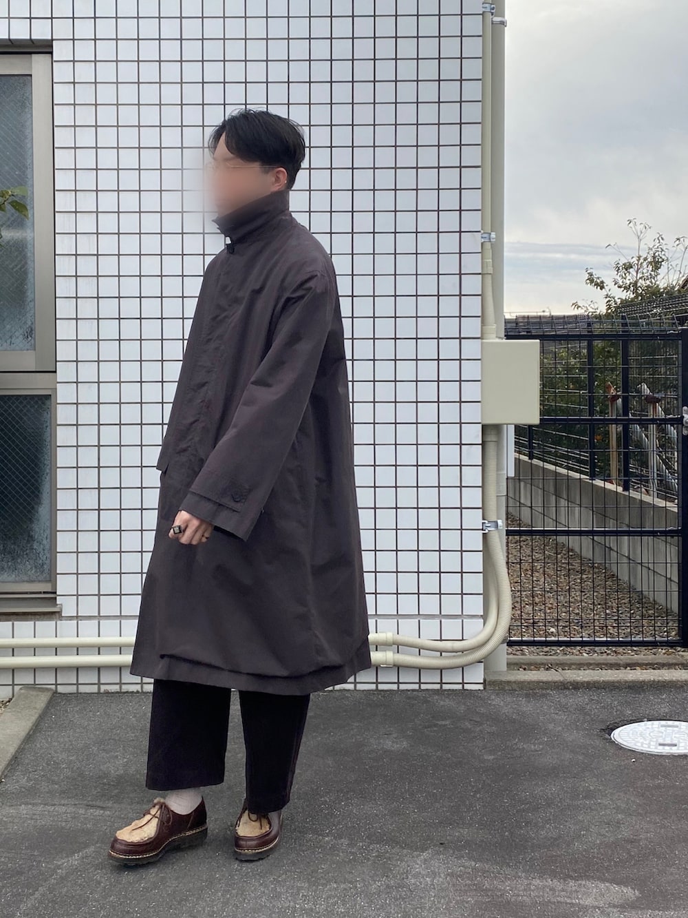 ブラウン系のステンカラーコート、ブラウン系のチノパンツ、ブラウン系のドレスシューズを着用したメンズの冬コーディネートの2枚目の写真