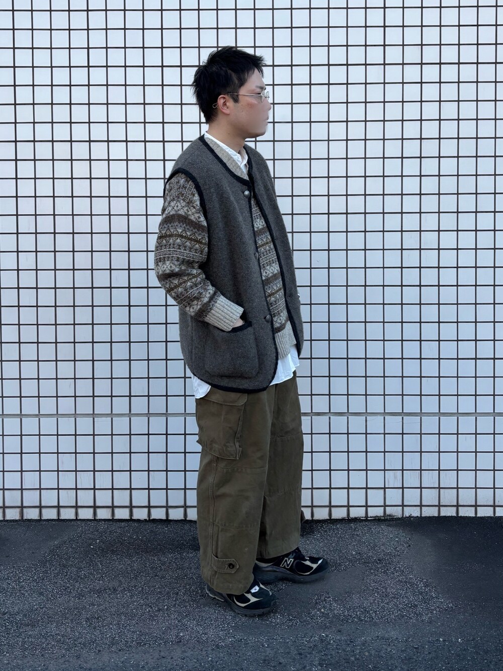 グレー系のベスト、グリーン系のカーゴパンツ、その他のスニーカーを着用したメンズの冬コーディネートの2枚目の写真