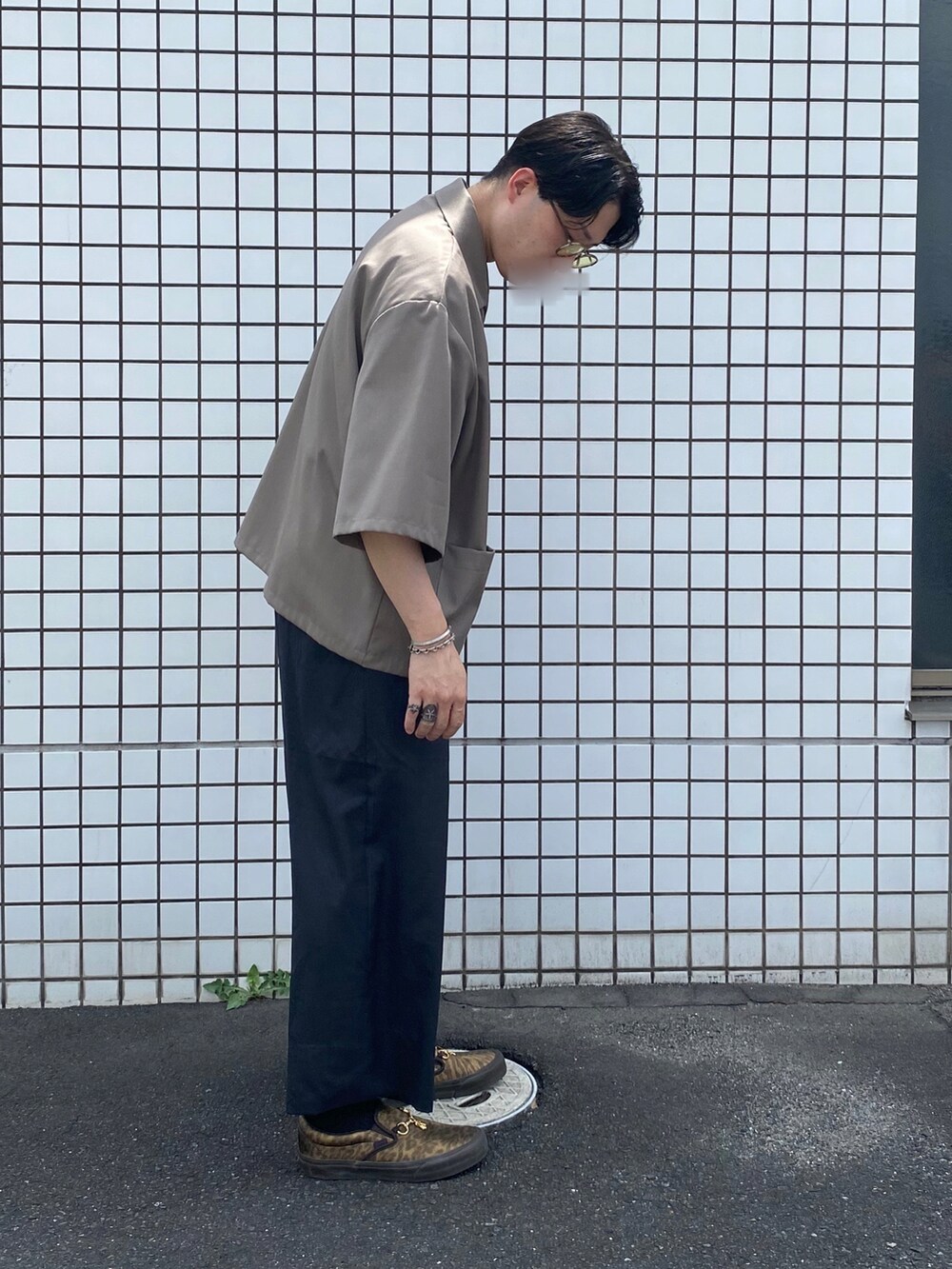 グレー系のスラックス、ゴールド系のスニーカー、グレー系のシャツ/ブラウスを着用したメンズの夏コーディネートの2枚目の写真