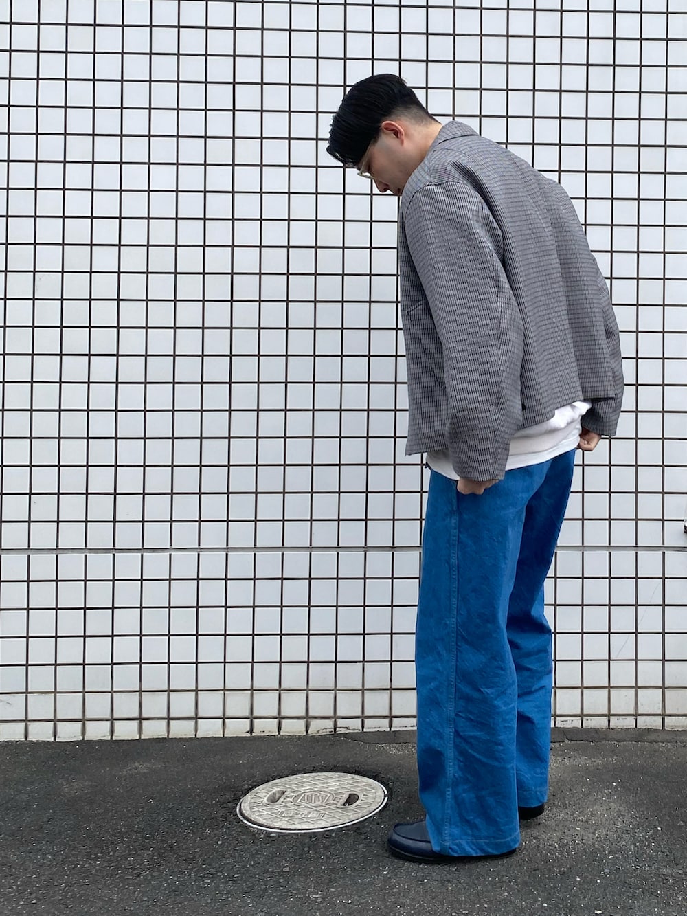 グレー系のブルゾン、ブルー系のデニムパンツ、ベージュ系のスウェットを着用したメンズの冬コーディネートの2枚目の写真