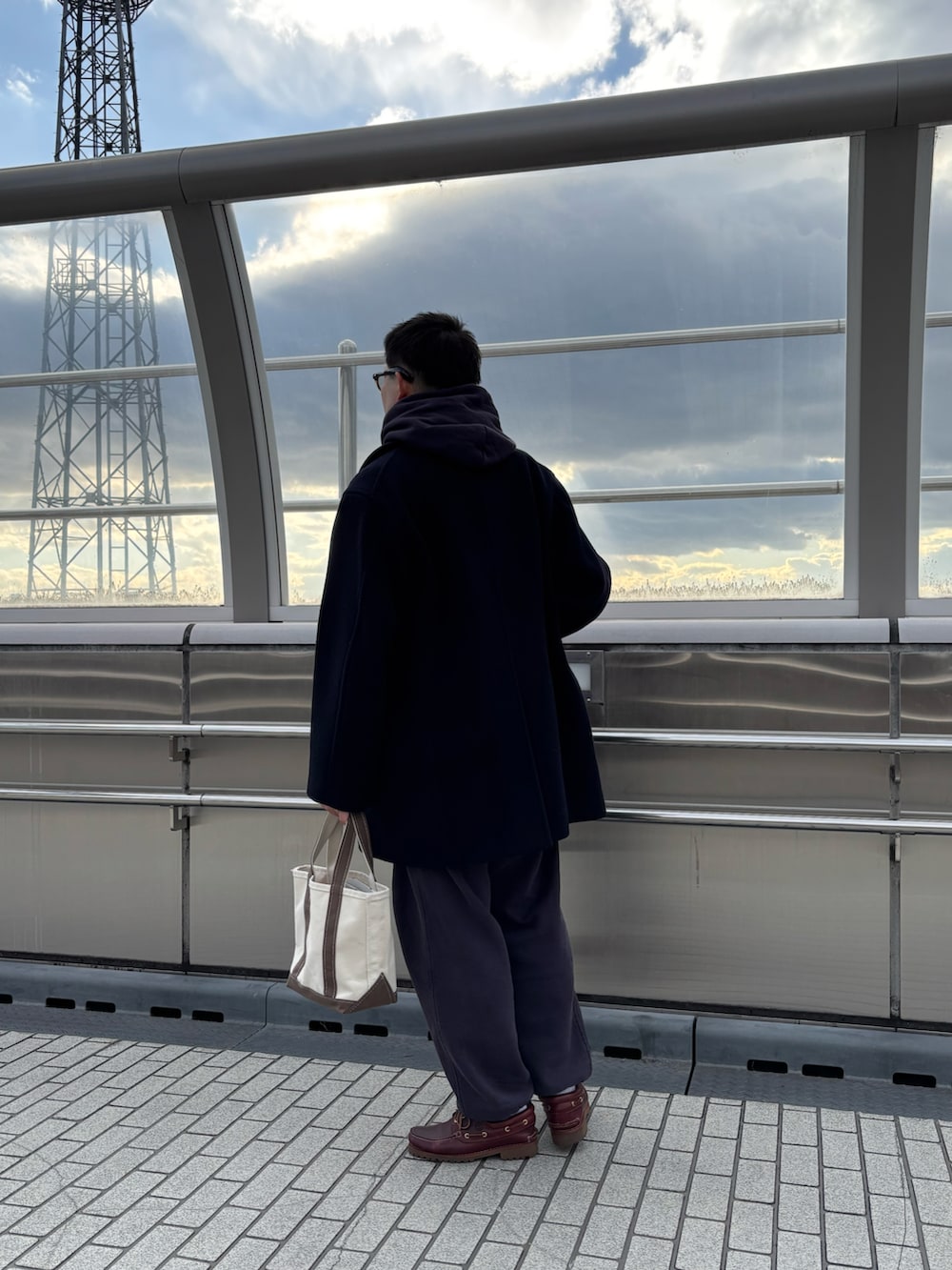 ブルー系のパーカー、ブルー系のピーコート、ブルー系のスウェットパンツを着用したメンズの冬コーディネートの3枚目の写真