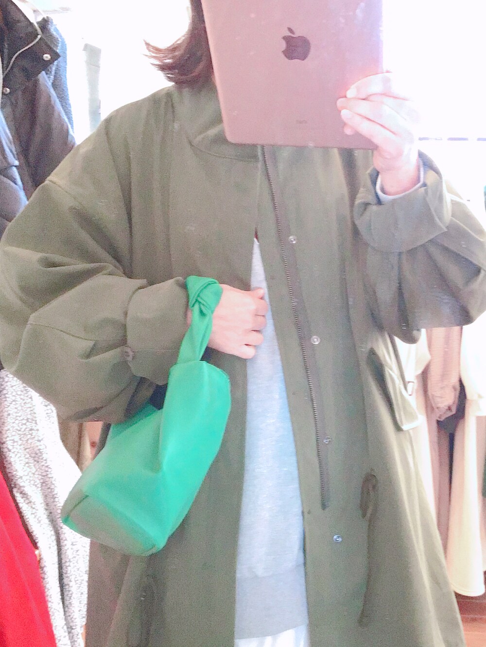 ホワイト系のスカート、グリーン系のモッズコート、グリーン系のスニーカーを着用したレディースの冬コーディネートの2枚目の写真