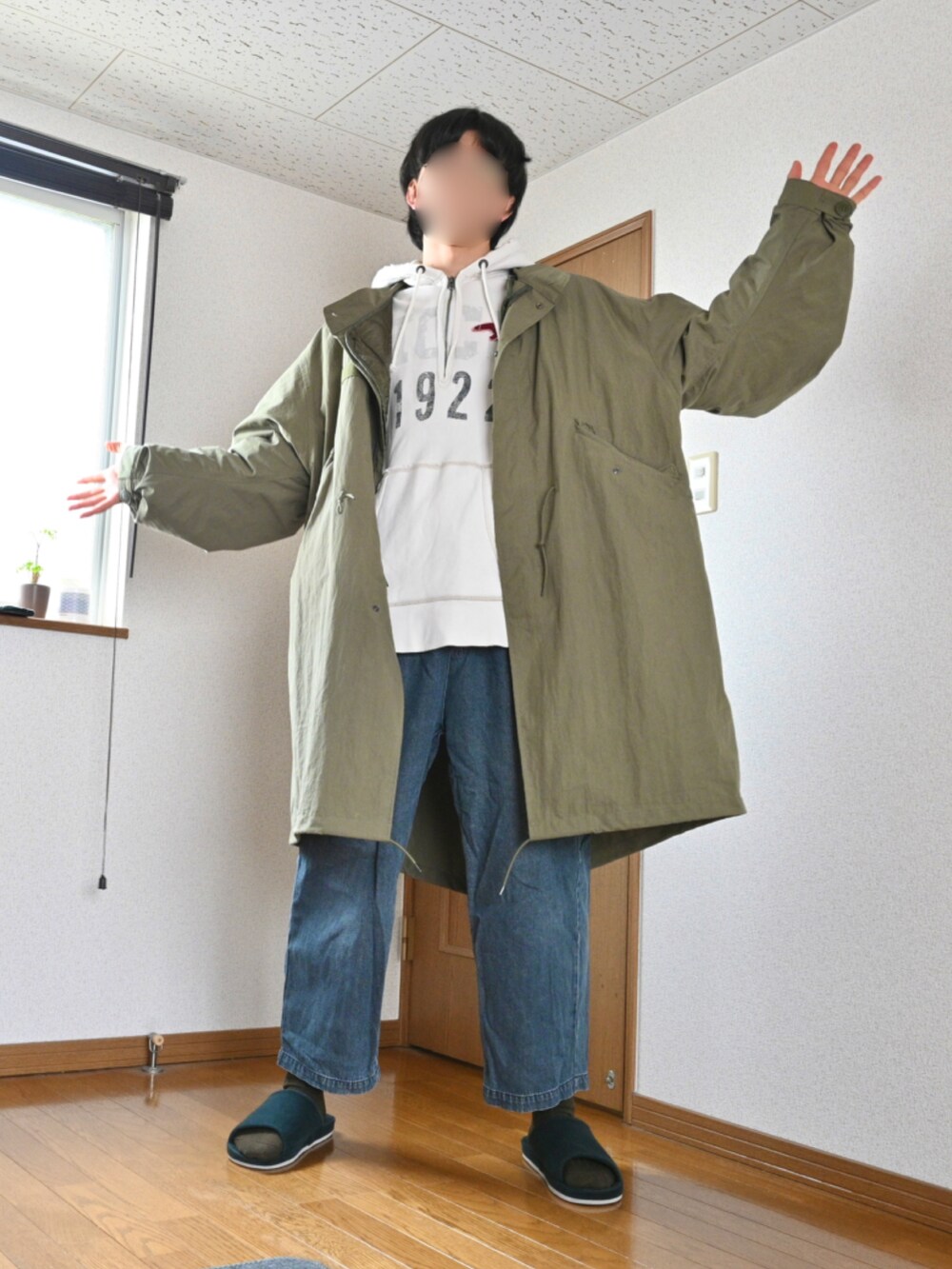 グリーン系のモッズコート、ブラック系のデニムパンツを着用したメンズの冬コーディネートの3枚目の写真