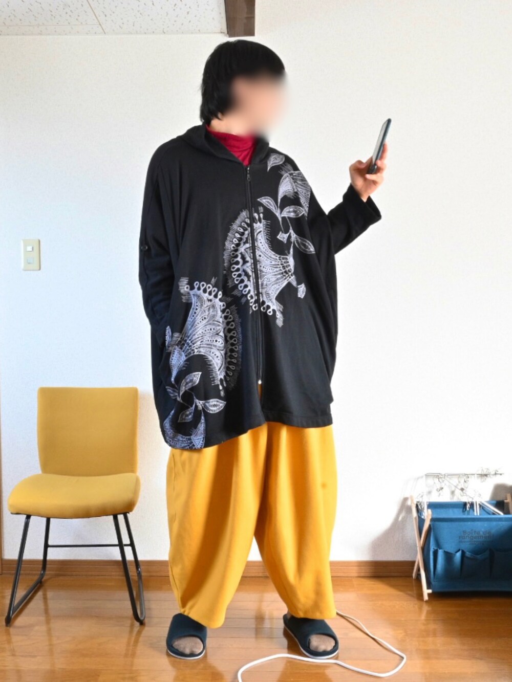 ブラック系のパーカー、イエロー系のその他パンツ、ベージュ系のポンチョを着用したメンズの冬コーディネートの3枚目の写真