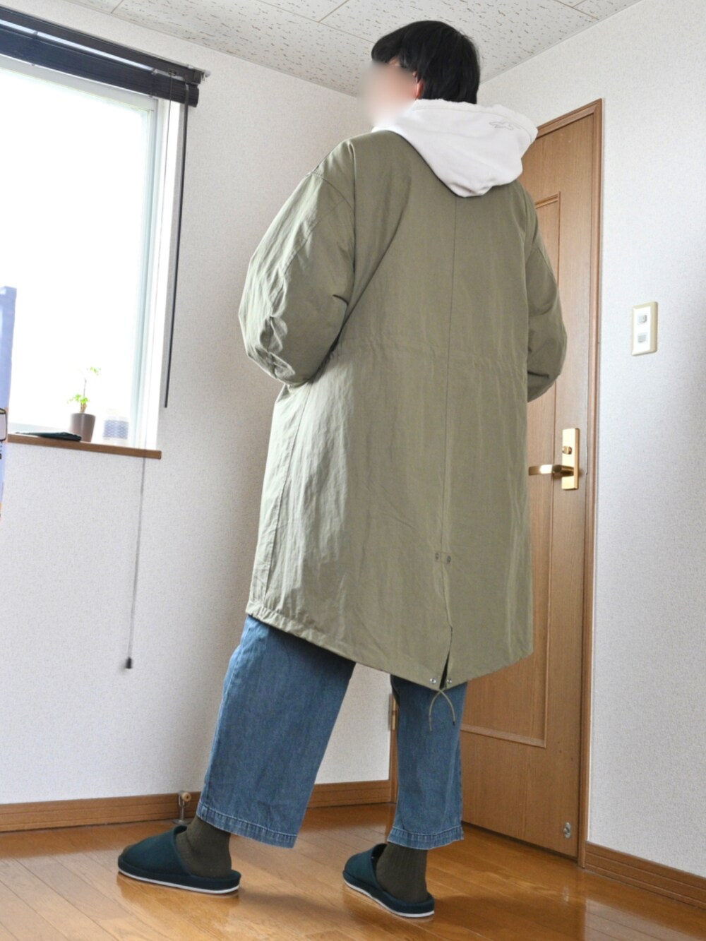 グリーン系のモッズコート、ブラック系のデニムパンツを着用したメンズの冬コーディネートの2枚目の写真