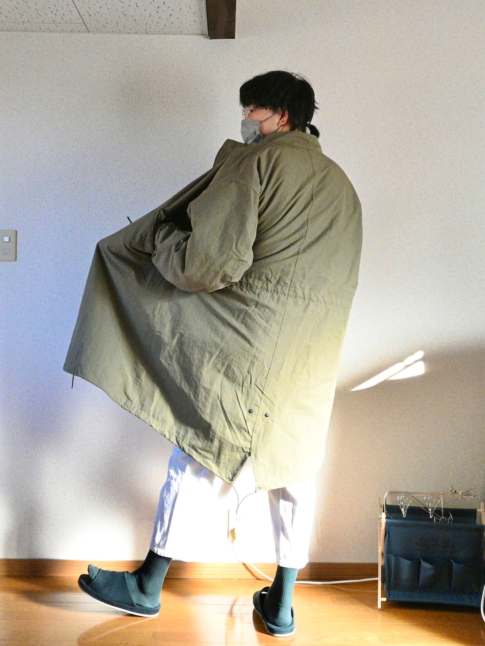 パープル系のスウェット、グリーン系のモッズコート、ホワイト系のパンツを着用したメンズの冬コーディネートの2枚目の写真