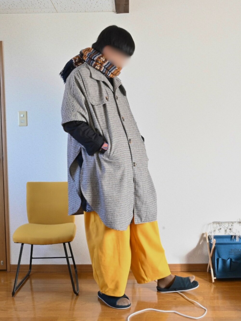 ブラック系のパーカー、イエロー系のその他パンツ、ベージュ系のポンチョを着用したメンズの冬コーディネートの2枚目の写真