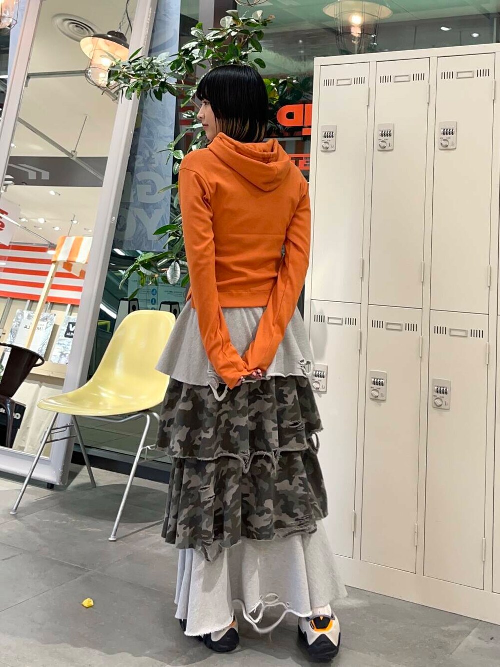 オレンジ系のパーカー、その他のスカートを着用したレディースの冬コーディネートの3枚目の写真