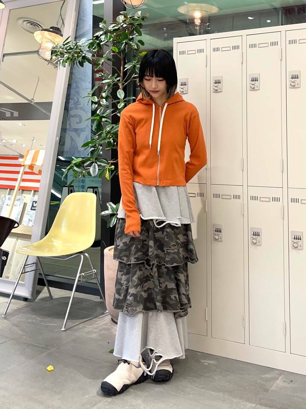 オレンジ系のパーカー、その他のスカートを着用したレディースの冬コーディネートの2枚目の写真