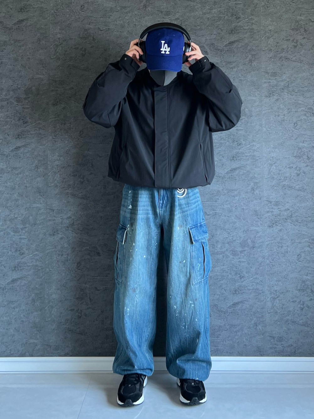 ブルー系のデニムパンツ、ブラック系のブルゾン、ブラック系のスニーカーを着用したメンズの秋コーディネートの2枚目の写真