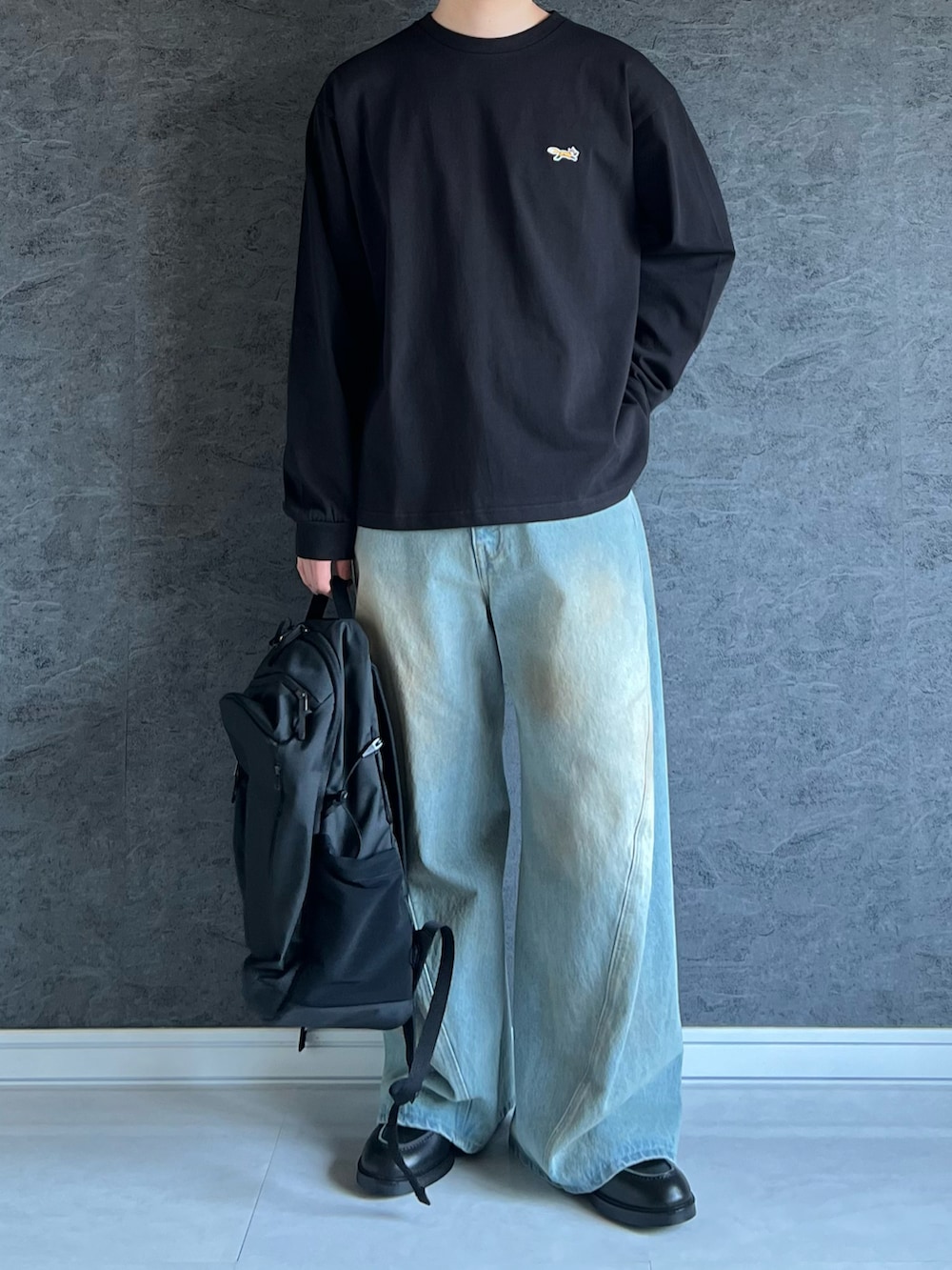 ブラック系のTシャツ/カットソーを着用したメンズの秋コーディネートの2枚目の写真