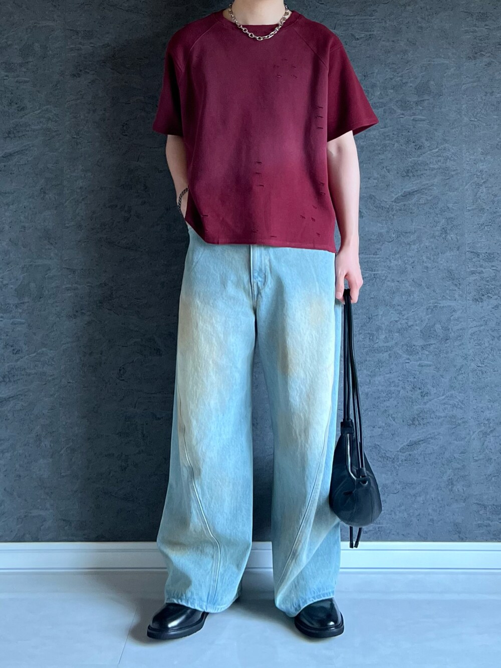 レッド系のTシャツ/カットソー、ブルー系のデニムパンツ、ブラック系のショルダーバッグを着用したメンズの夏コーディネートの2枚目の写真