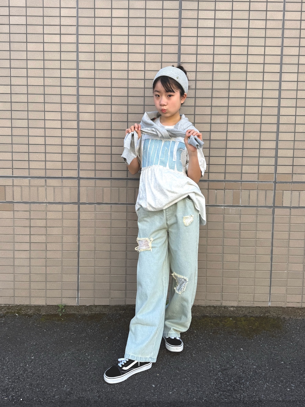 グレー系のワンピース、グレー系のワンピース、ブルー系のデニムパンツを着用したキッズの春コーディネートの3枚目の写真