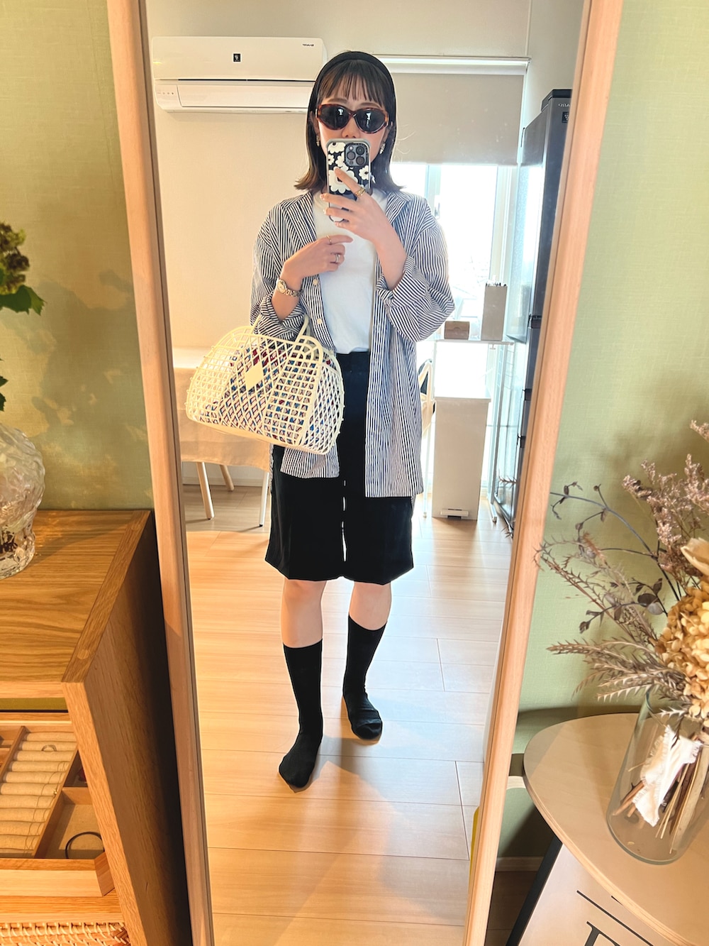 ホワイト系のかごバッグ、ブルー系のシャツ/ブラウス、ホワイト系のTシャツ/カットソーを着用したレディースの春コーディネートの2枚目の写真
