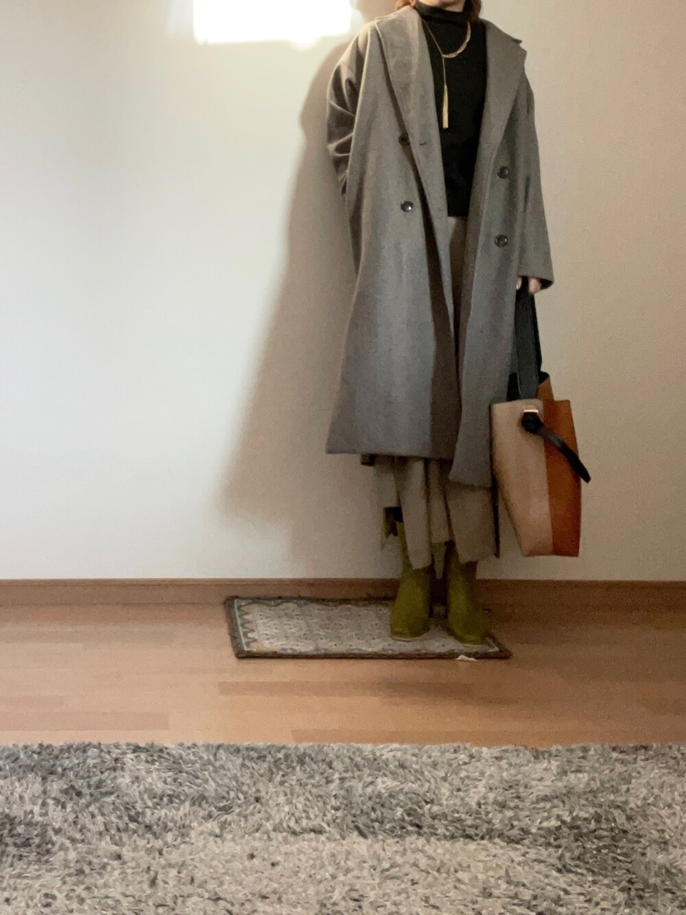 ブラック系のセットアップ、ベージュ系のスカート、グリーン系のブーツを着用したレディースの秋コーディネートの2枚目の写真