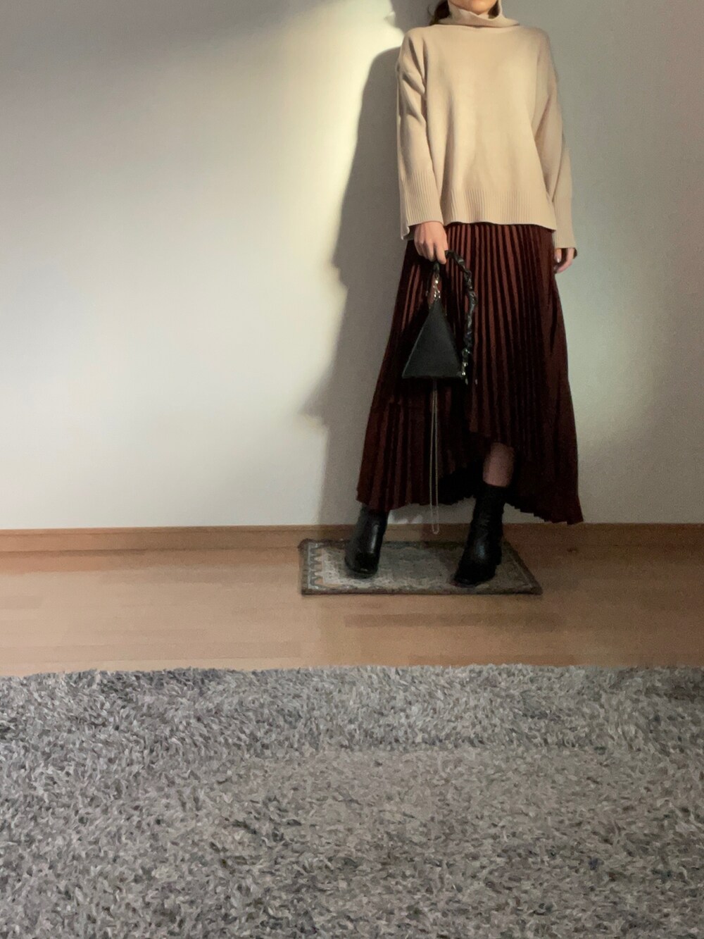 ブラック系のダウンジャケット/コート、ブラック系のハンドバッグ、ブラウン系のスカートを着用したレディースの秋コーディネートの2枚目の写真