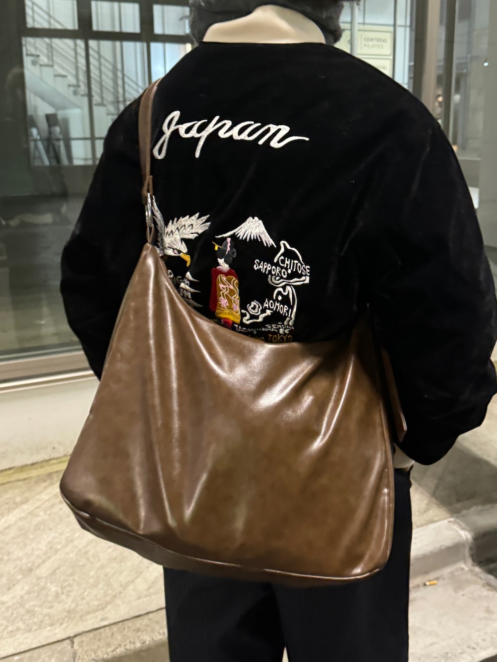 ブラック系のスカジャン、ブルー系のその他パンツ、ブラック系のスリッポンを着用したメンズの冬コーディネートの3枚目の写真