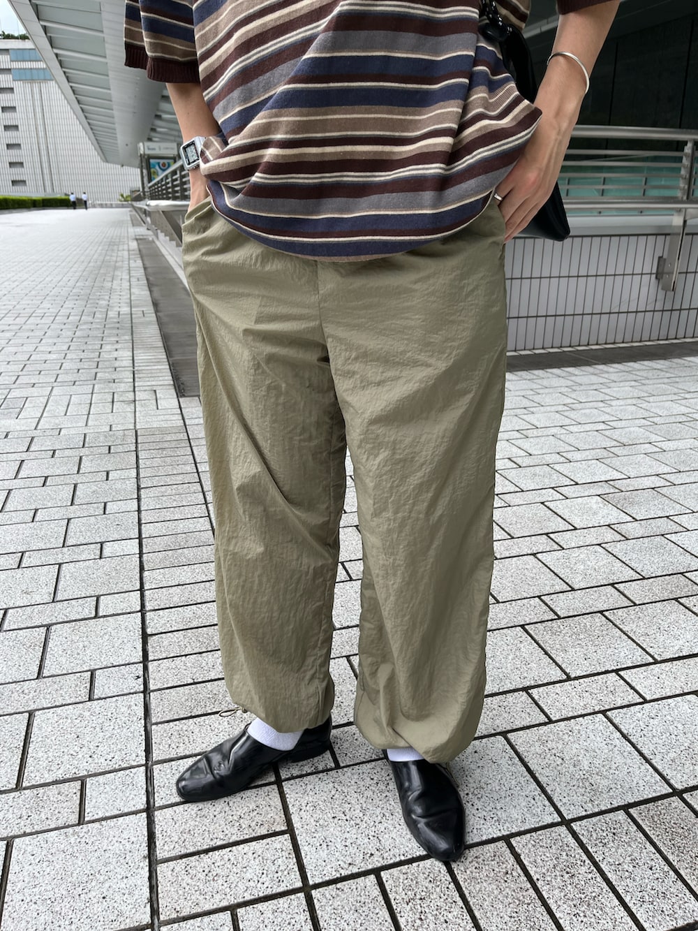 ブラウン系のTシャツ/カットソー、ブラック系のショルダーバッグ、グリーン系のカーゴパンツを着用したメンズの夏コーディネートの2枚目の写真