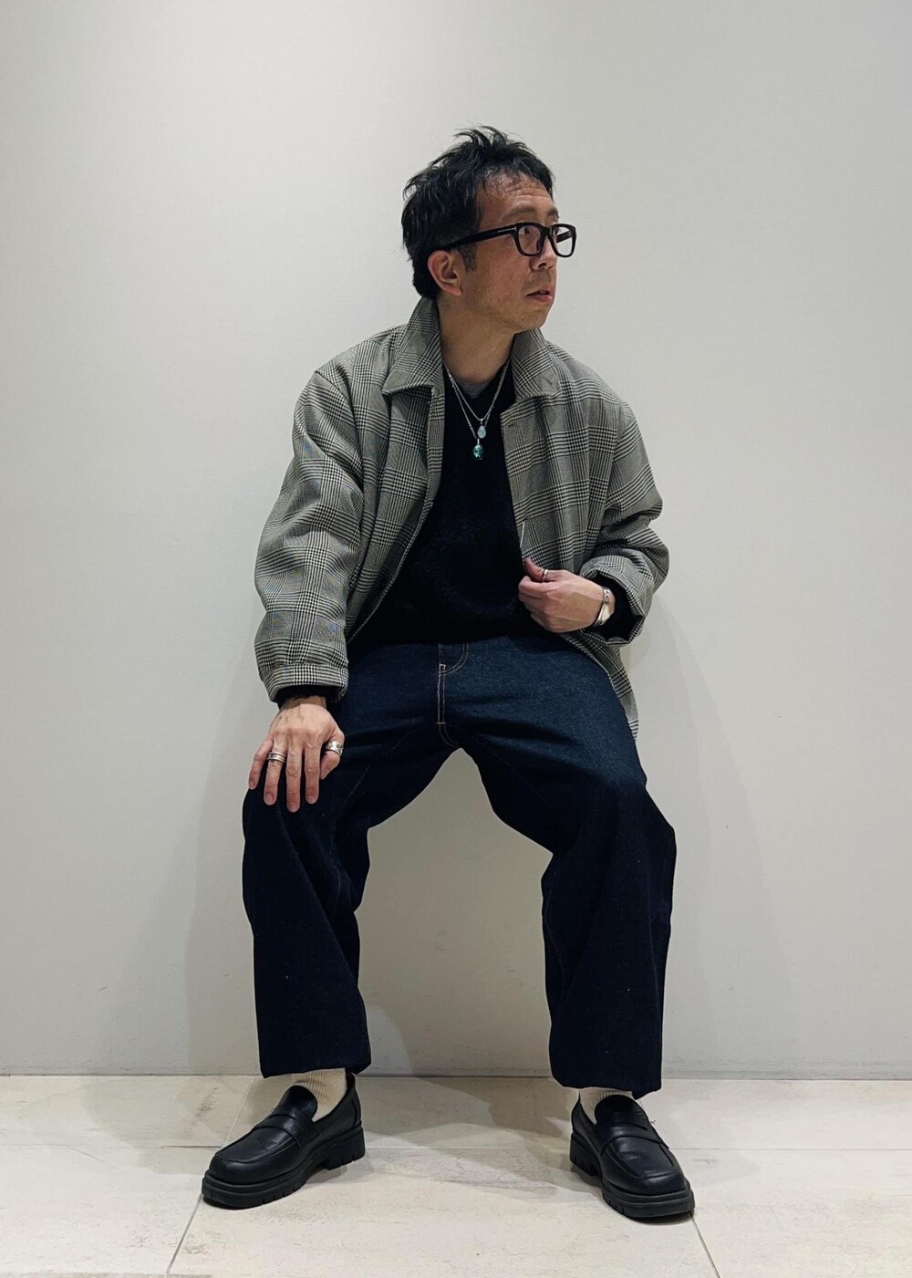 ブラック系のローファー、ブルー系のデニムパンツ、ブラック系のニット/セーターを着用したメンズの冬コーディネートの6枚目の写真