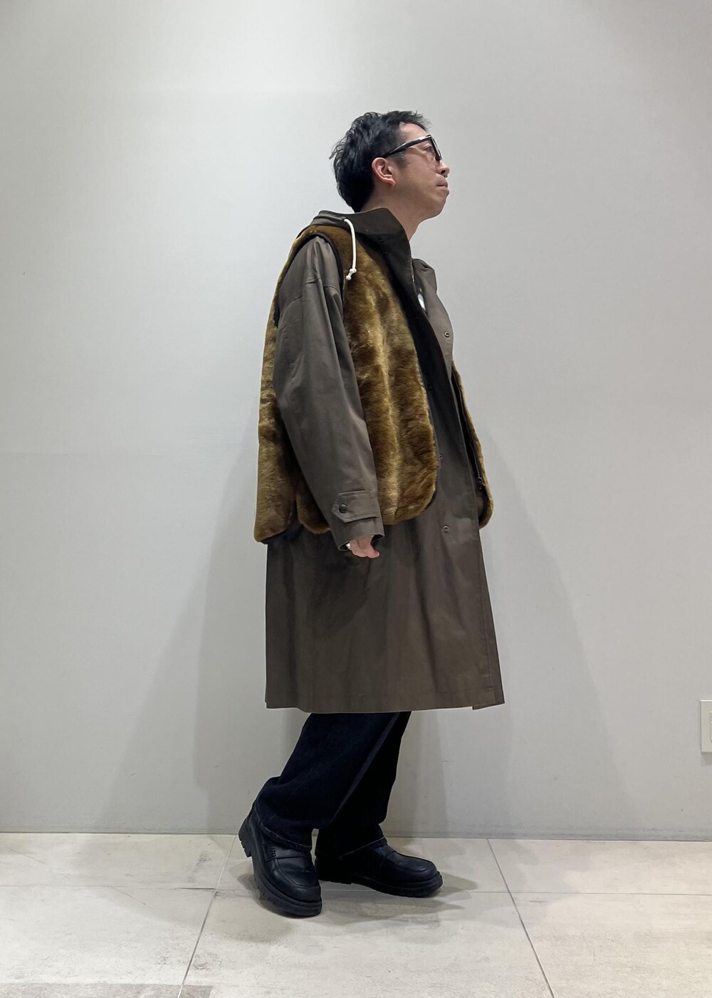 グリーン系のニット/セーター、ブラック系のローファー、ブルー系のデニムパンツを着用したメンズの冬コーディネートの2枚目の写真