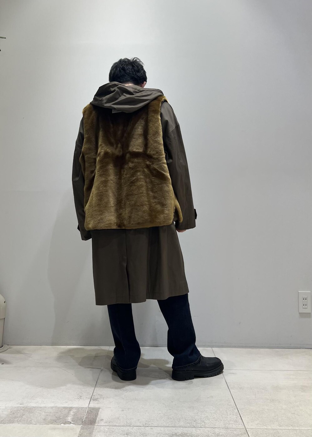 グリーン系のニット/セーター、ブラック系のローファー、ブルー系のデニムパンツを着用したメンズの冬コーディネートの3枚目の写真