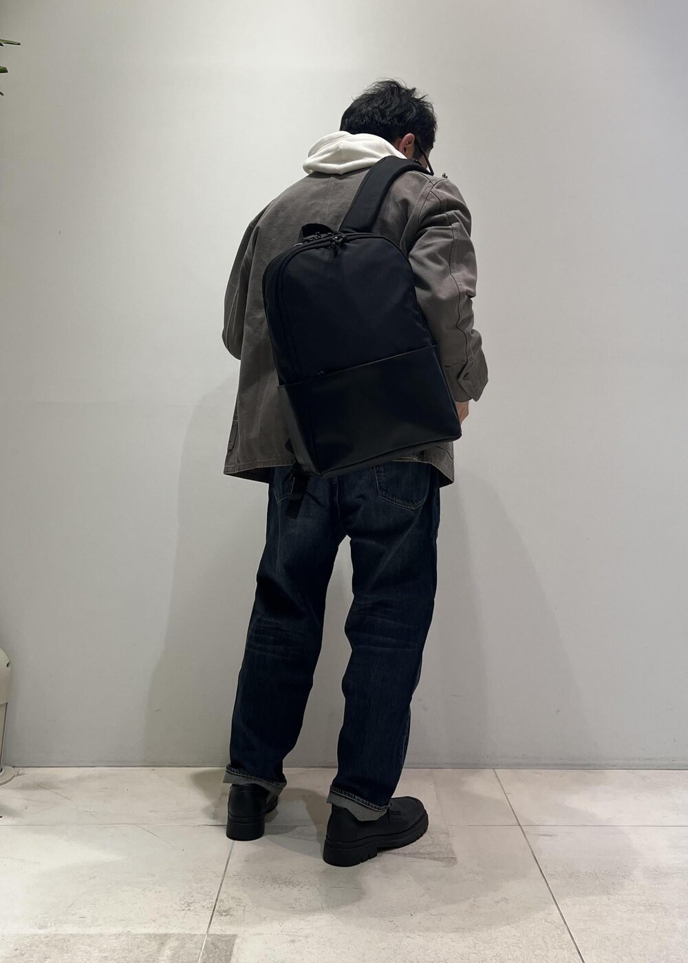 ブルー系のデニムパンツ、ブラック系のローファー、グレー系のカバーオールを着用したメンズの冬コーディネートの8枚目の写真