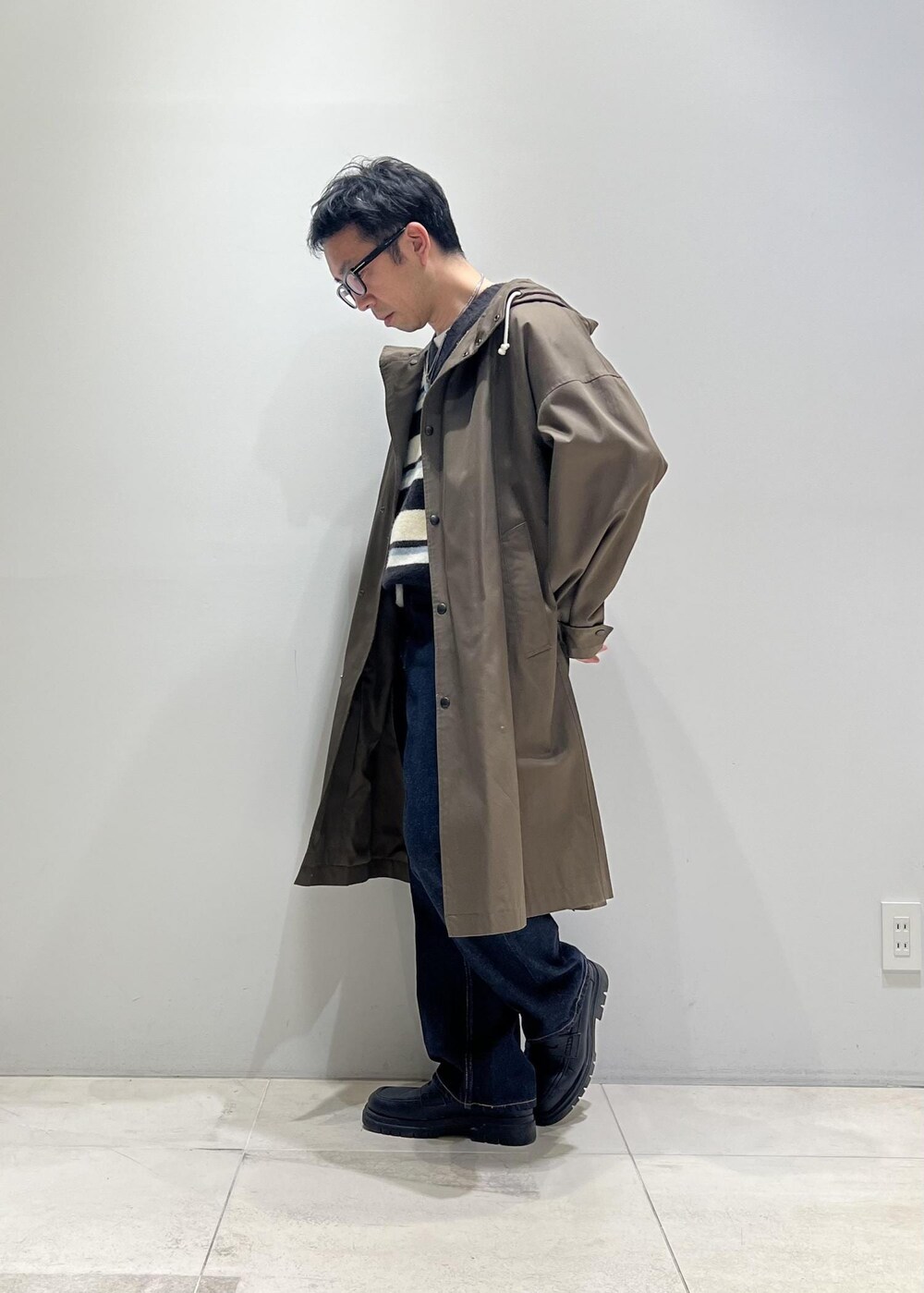 グリーン系のニット/セーター、ブラック系のローファー、ブルー系のデニムパンツを着用したメンズの冬コーディネートの6枚目の写真