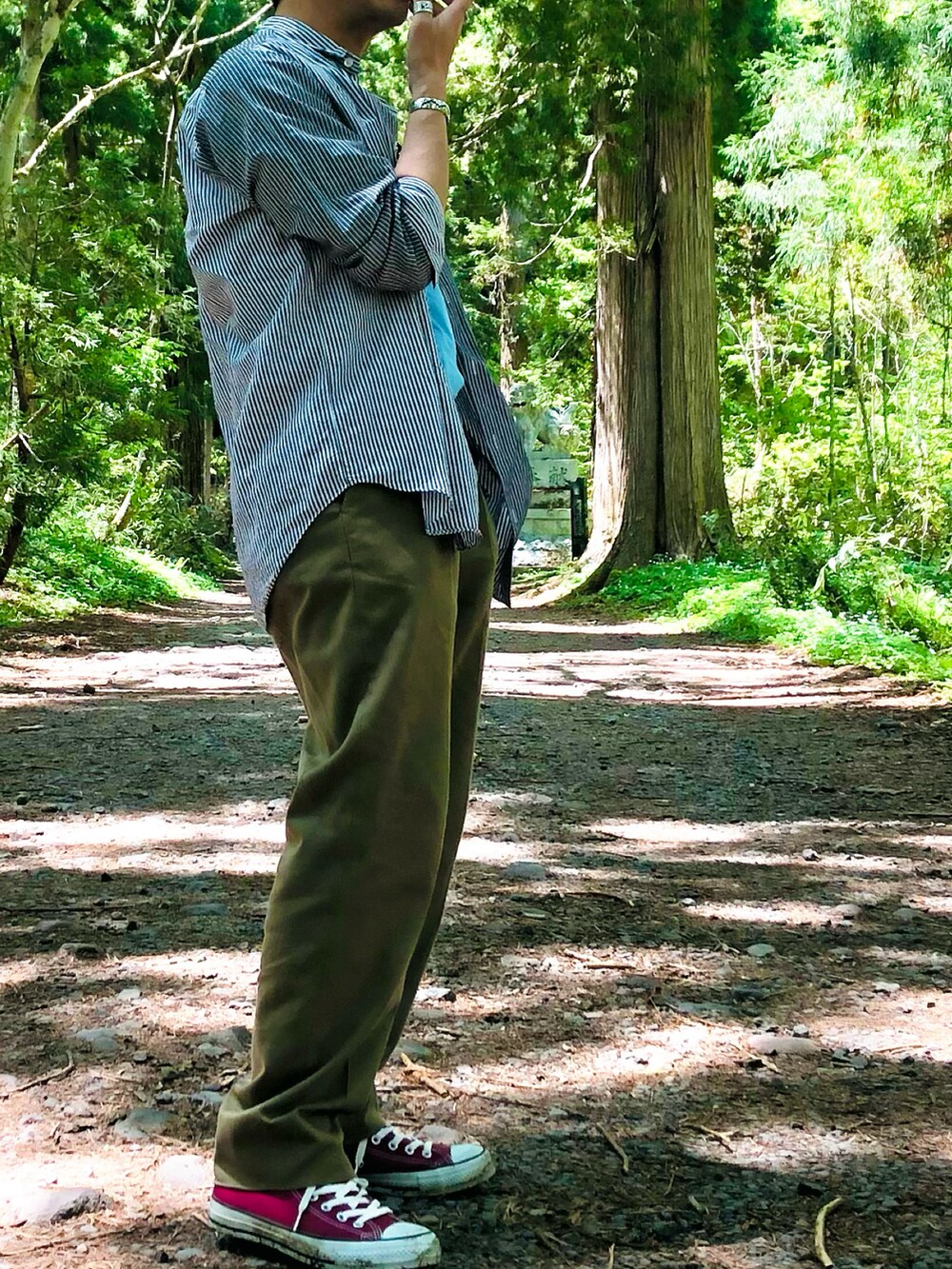 グリーン系のスラックス、グレー系のシャツ/ブラウス、ブルー系のTシャツ/カットソーを着用したメンズの春コーディネートの3枚目の写真