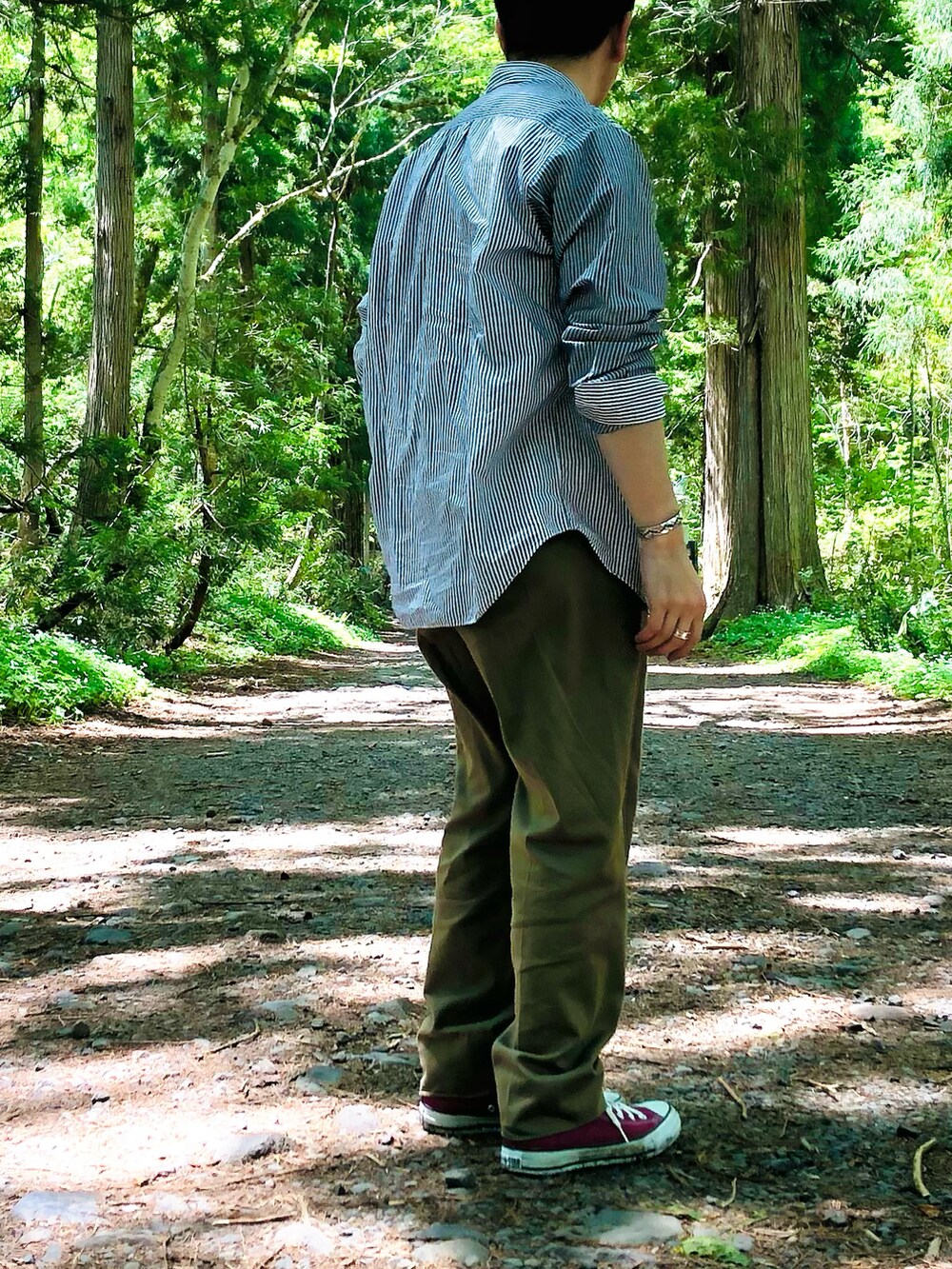 グリーン系のスラックス、グレー系のシャツ/ブラウス、ブルー系のTシャツ/カットソーを着用したメンズの春コーディネートの2枚目の写真