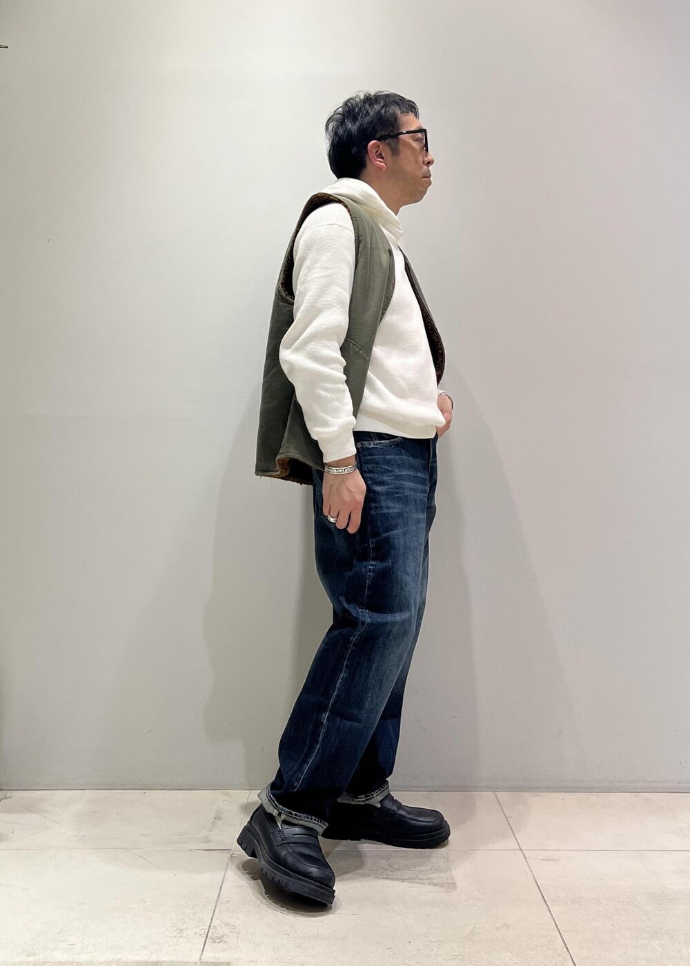 ブルー系のデニムパンツ、ブラック系のローファー、グレー系のカバーオールを着用したメンズの冬コーディネートの6枚目の写真