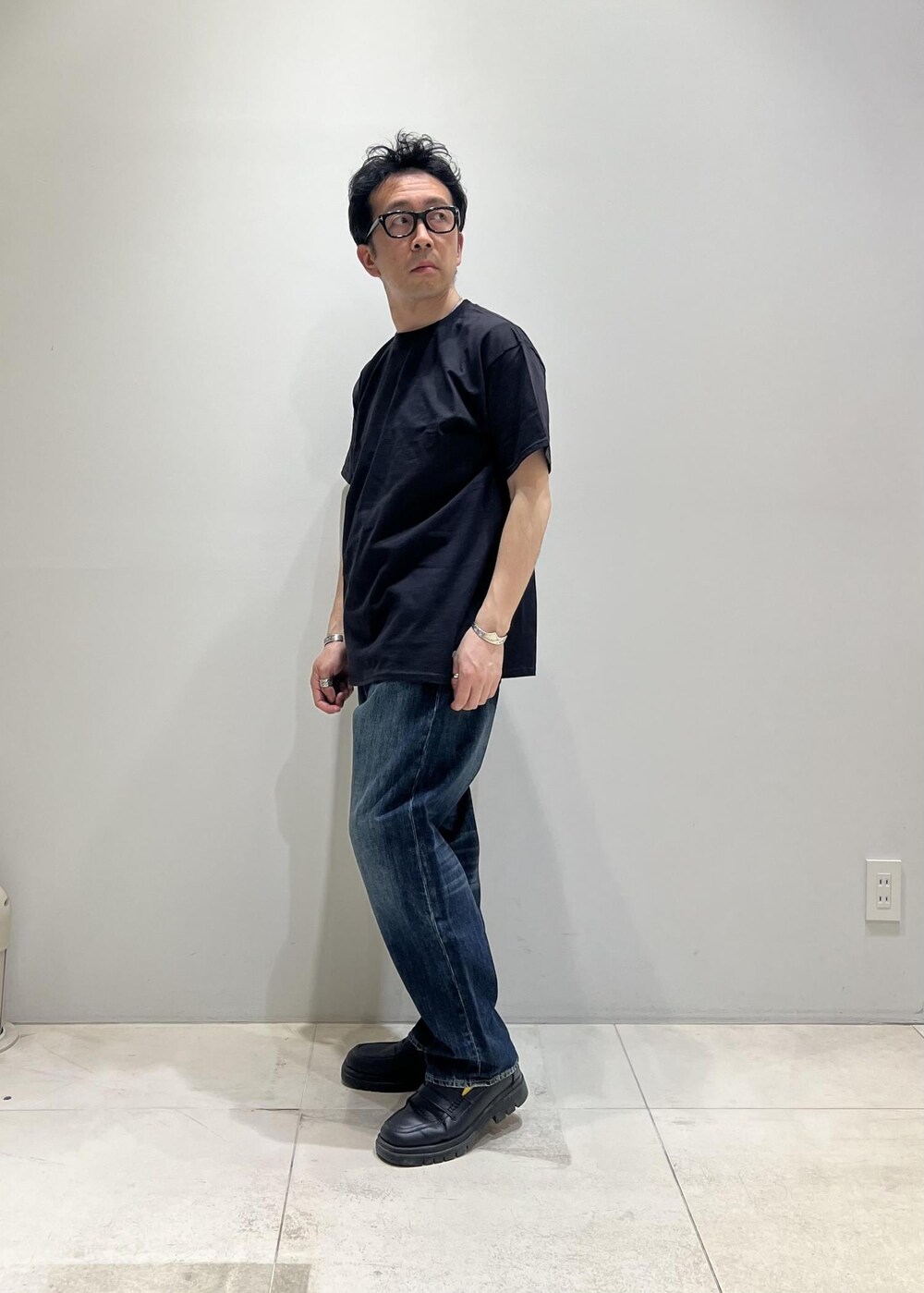ブルー系のデニムパンツ、ホワイト系のシャツ/ブラウス、ブラック系のTシャツ/カットソーを着用したメンズの春コーディネートの4枚目の写真