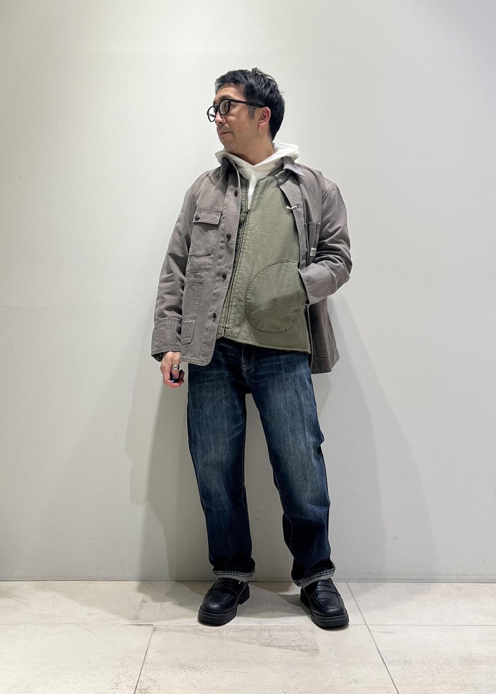 ブルー系のデニムパンツ、ブラック系のローファー、グレー系のカバーオールを着用したメンズの冬コーディネートの7枚目の写真