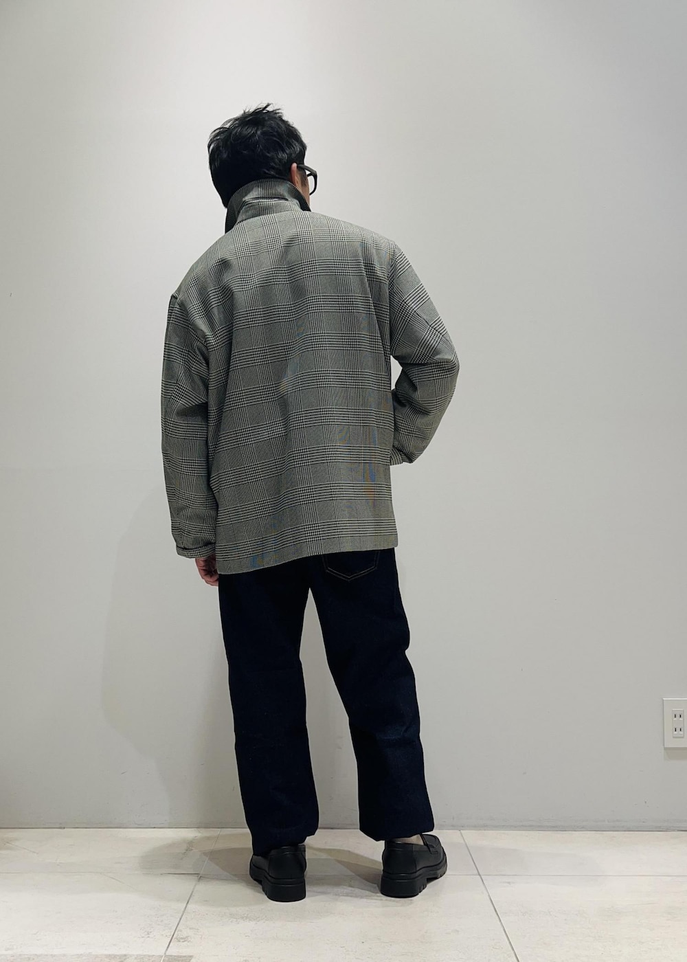 ブラック系のローファー、ブルー系のデニムパンツ、ブラック系のニット/セーターを着用したメンズの冬コーディネートの3枚目の写真