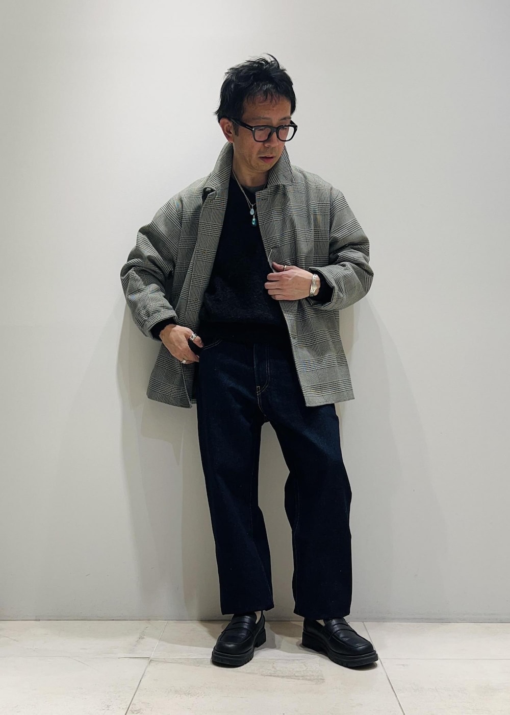 ブラック系のローファー、ブルー系のデニムパンツ、ブラック系のニット/セーターを着用したメンズの冬コーディネートの5枚目の写真
