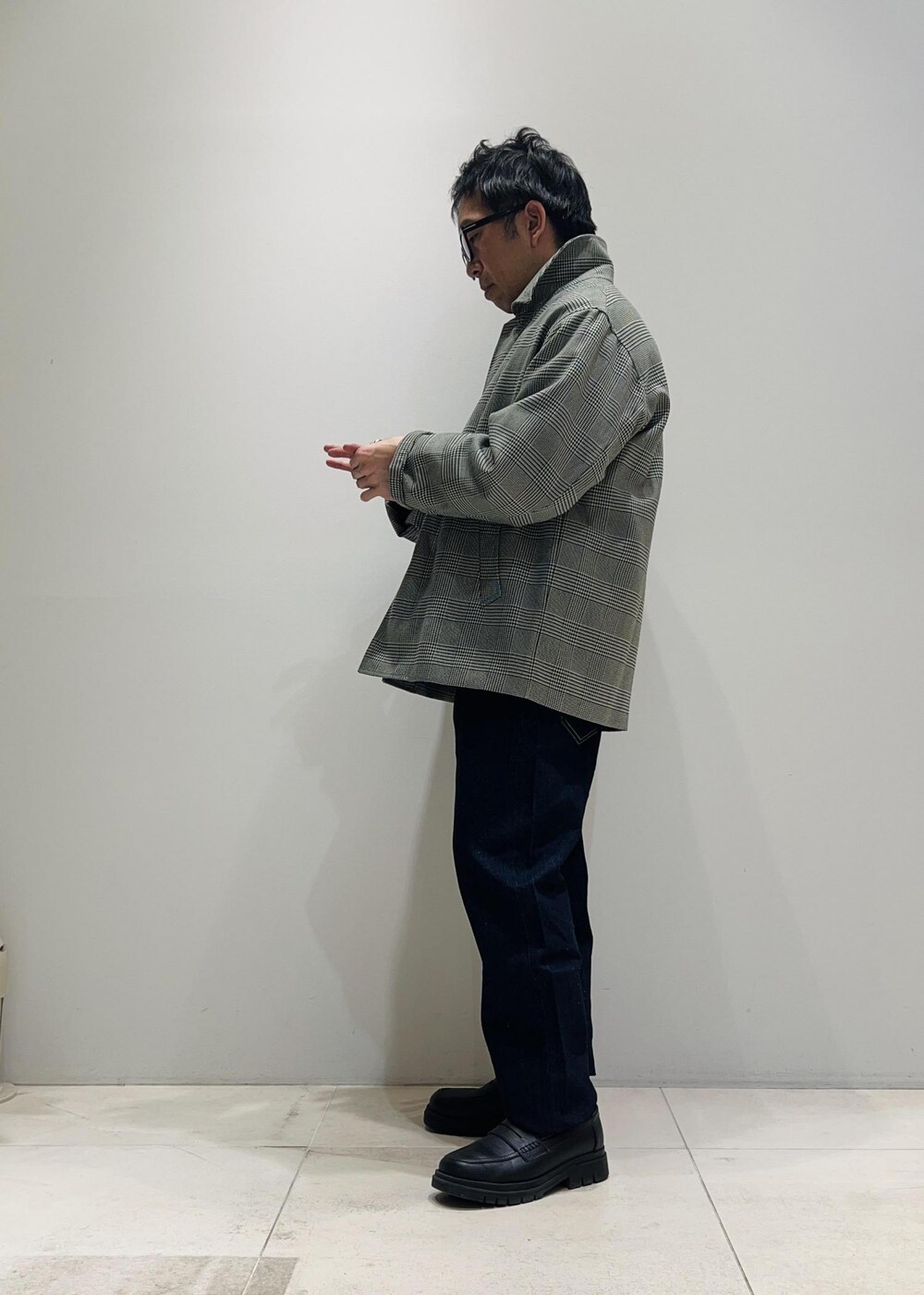 ブラック系のローファー、ブルー系のデニムパンツ、ブラック系のニット/セーターを着用したメンズの冬コーディネートの2枚目の写真