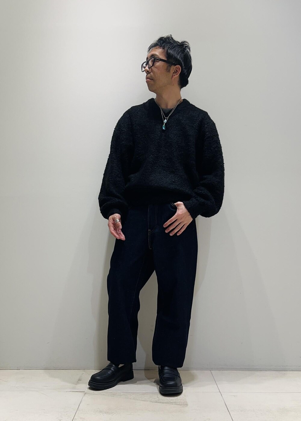 ブラック系のローファー、ブルー系のデニムパンツ、ブラック系のニット/セーターを着用したメンズの冬コーディネートの7枚目の写真