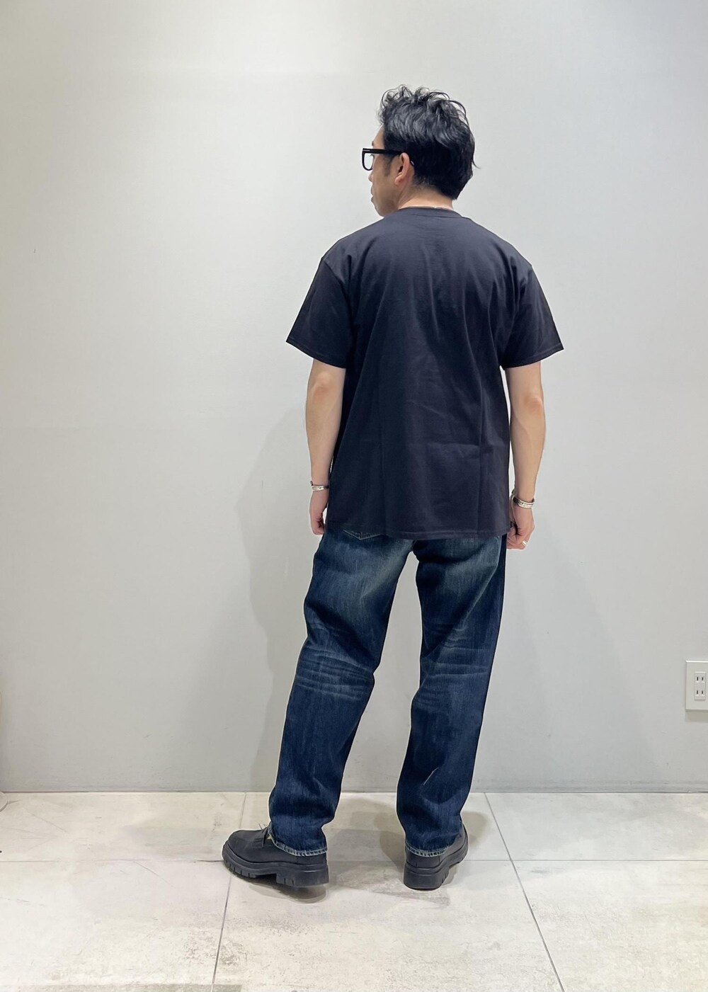 ブルー系のデニムパンツ、ホワイト系のシャツ/ブラウス、ブラック系のTシャツ/カットソーを着用したメンズの春コーディネートの3枚目の写真