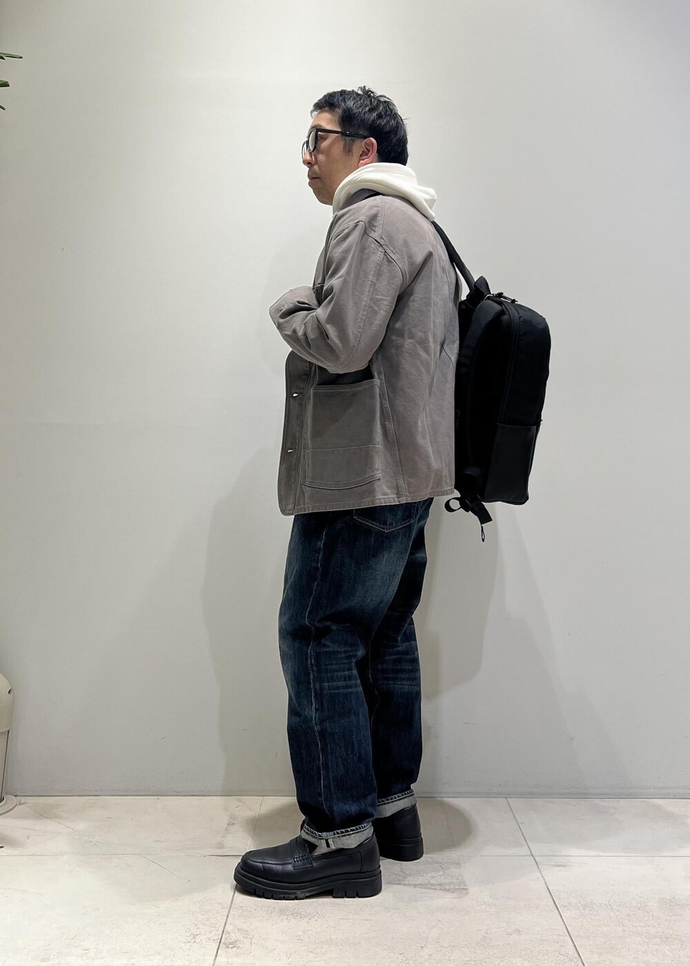 ブルー系のデニムパンツ、ブラック系のローファー、グレー系のカバーオールを着用したメンズの冬コーディネートの10枚目の写真