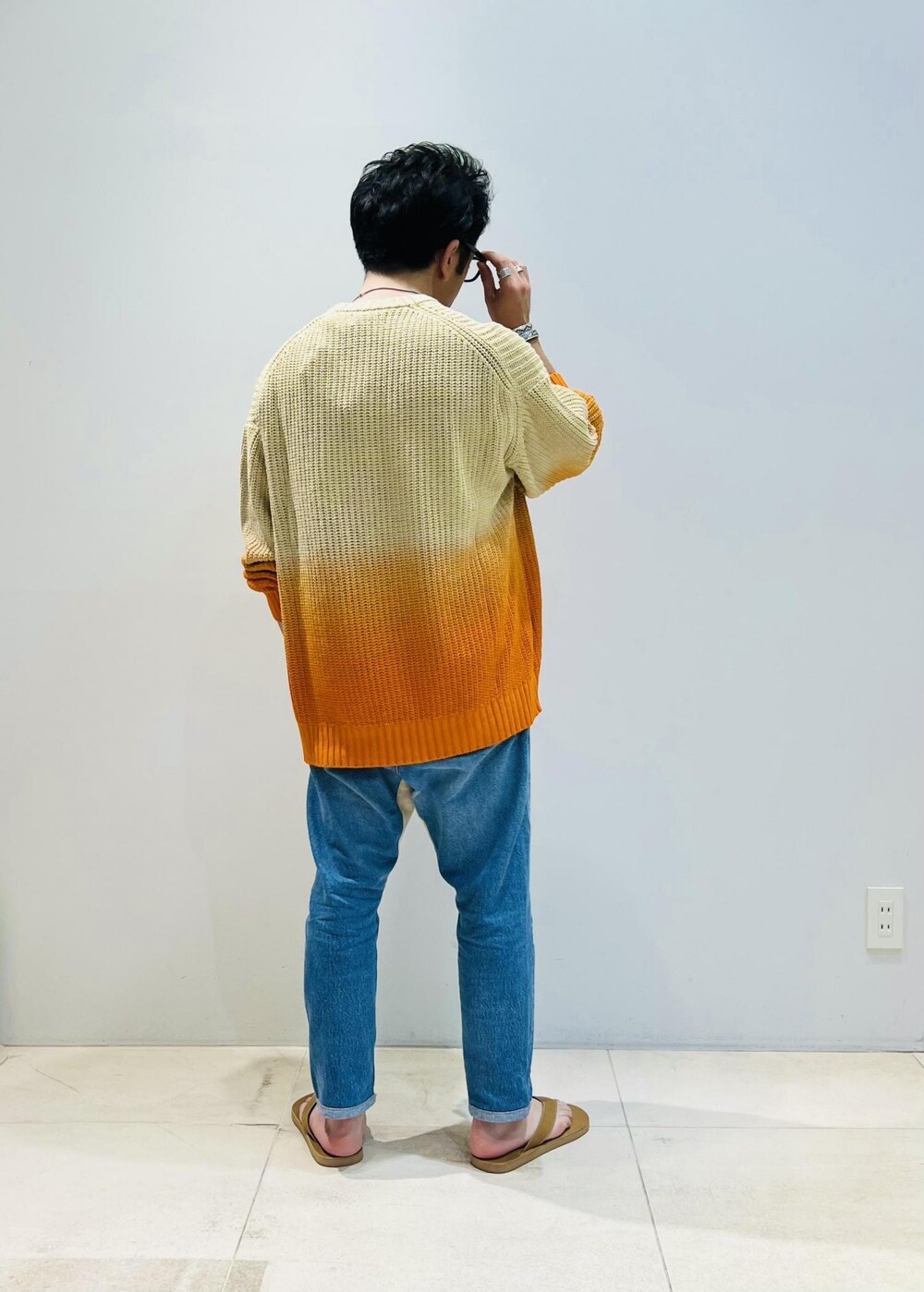 オレンジ系のニット/セーターを着用したメンズの夏コーディネートの3枚目の写真
