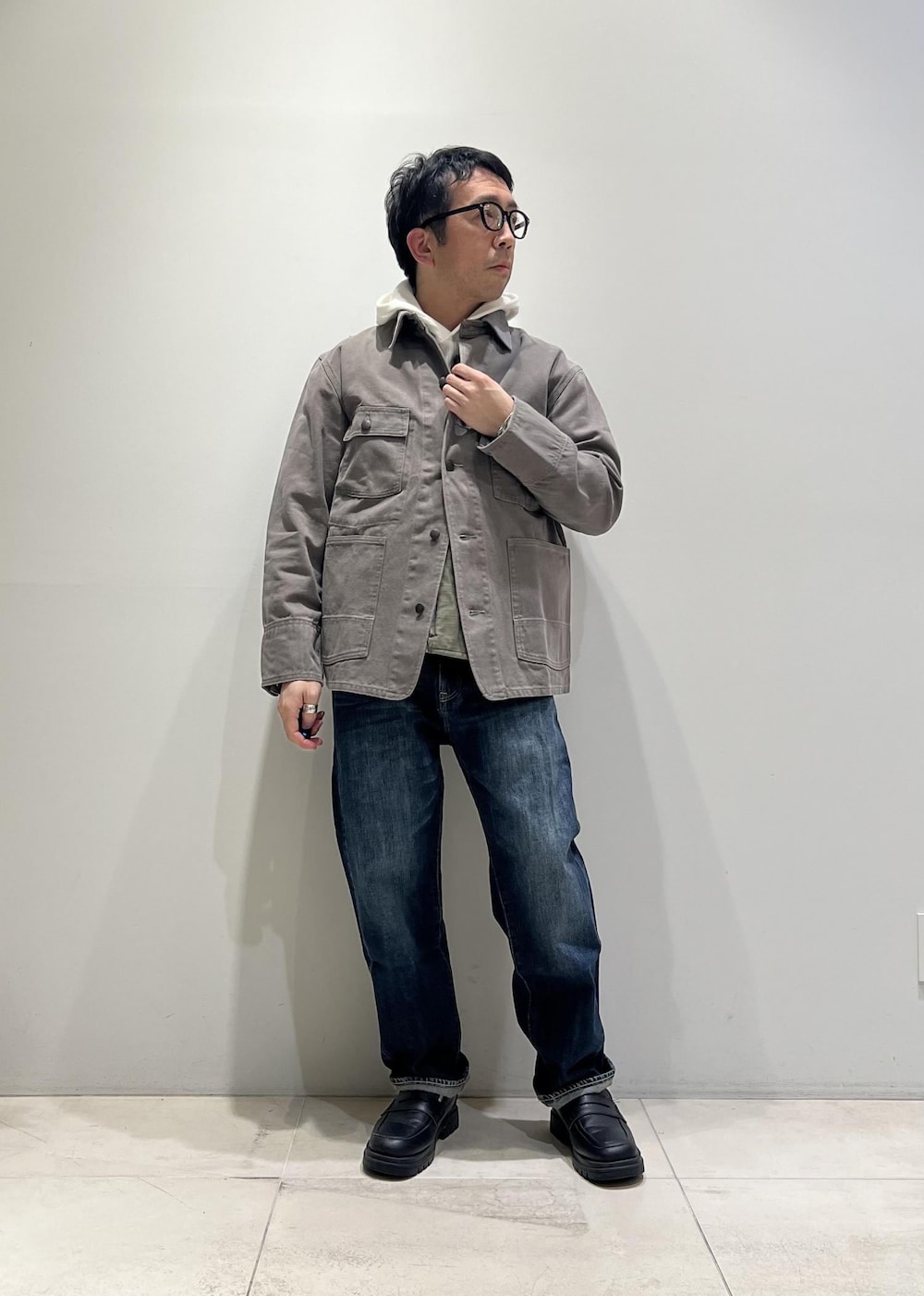 ブルー系のデニムパンツ、ブラック系のローファー、グレー系のカバーオールを着用したメンズの冬コーディネートの9枚目の写真